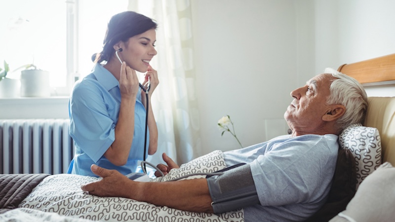 nurse taking the heartbeat and blood pressure of a resident with nursing needs
